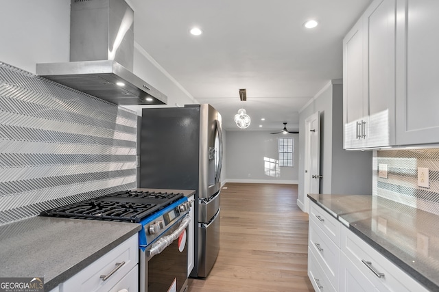 kitchen featuring stainless steel gas stove, wall chimney range hood, light wood-type flooring, and decorative backsplash