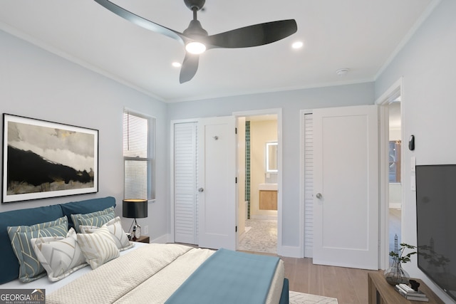 bedroom featuring ornamental molding, ceiling fan, ensuite bath, wood finished floors, and baseboards