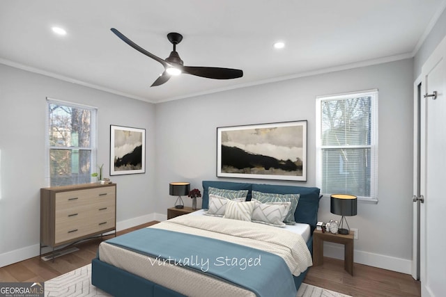 bedroom featuring ornamental molding, baseboards, and wood finished floors