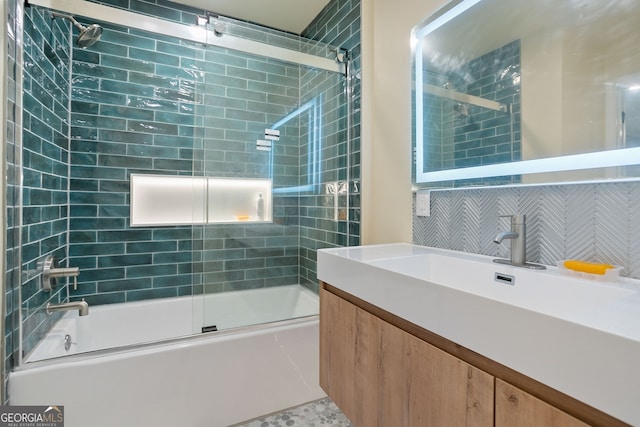 bathroom with backsplash, vanity, and shower / bath combination with glass door
