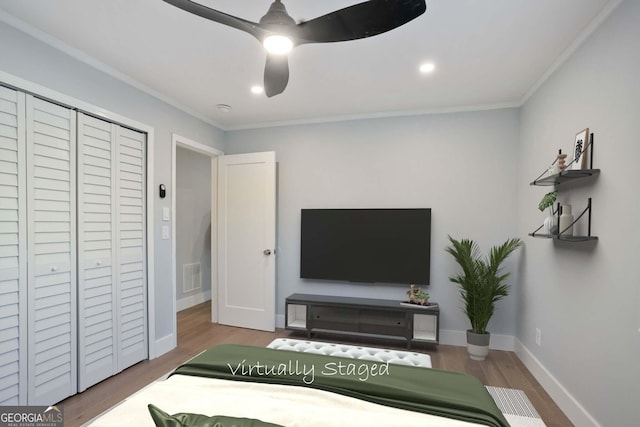 bedroom with baseboards, visible vents, crown molding, and wood finished floors