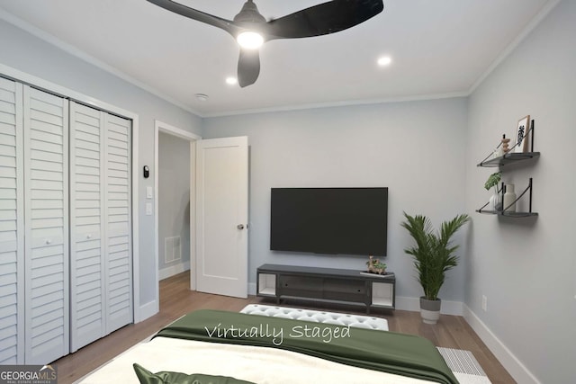 bedroom featuring baseboards, crown molding, visible vents, and wood finished floors