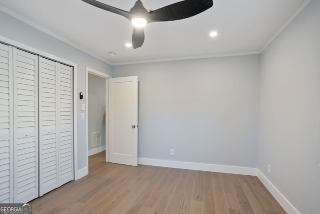 unfurnished bedroom featuring baseboards, visible vents, light wood-style floors, and crown molding