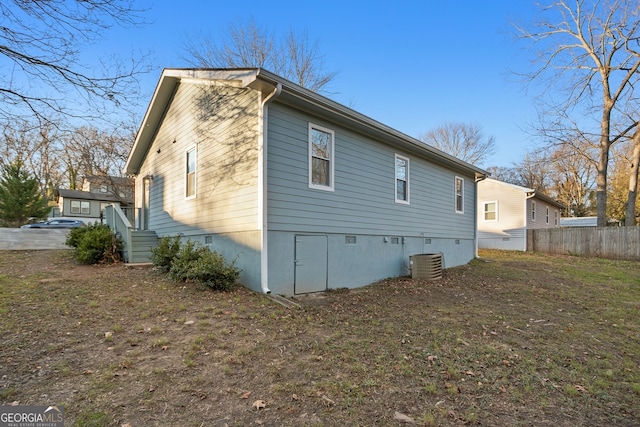 view of side of property with fence and cooling unit