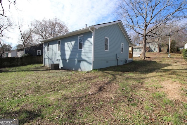 view of home's exterior with crawl space, central air condition unit, fence, and a yard