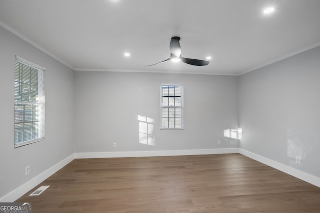 unfurnished room with visible vents, crown molding, baseboards, and wood finished floors