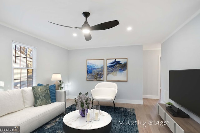 living area featuring recessed lighting, a ceiling fan, baseboards, ornamental molding, and light wood-type flooring