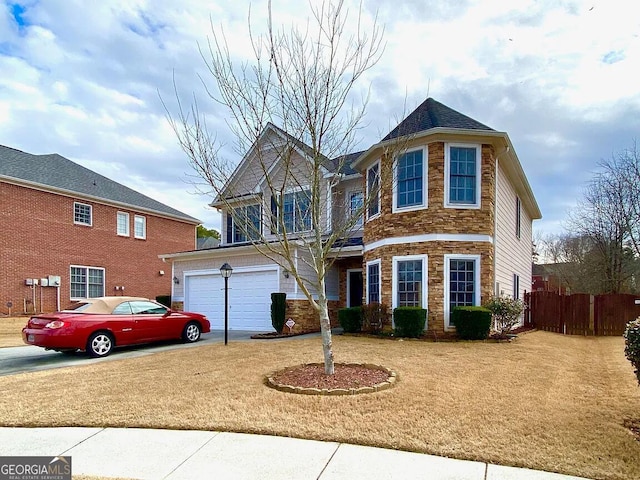 view of front of property with a garage, stone siding, fence, and driveway