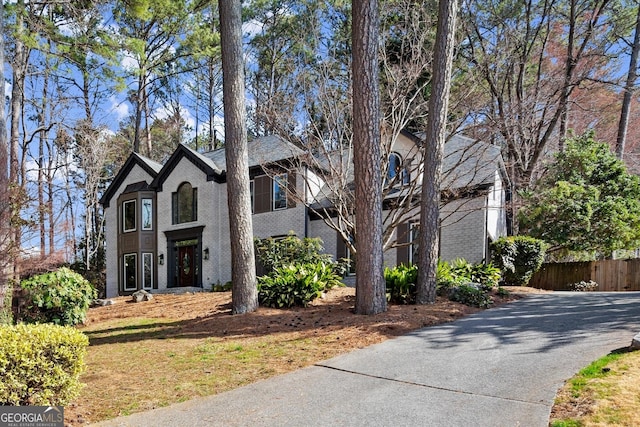 view of front of house featuring brick siding and fence