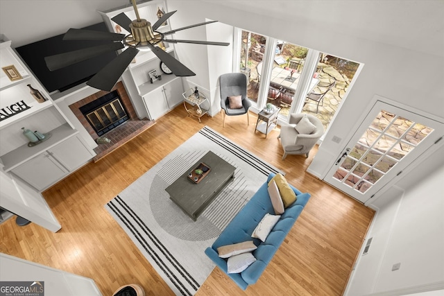 living area featuring wood finished floors and a glass covered fireplace