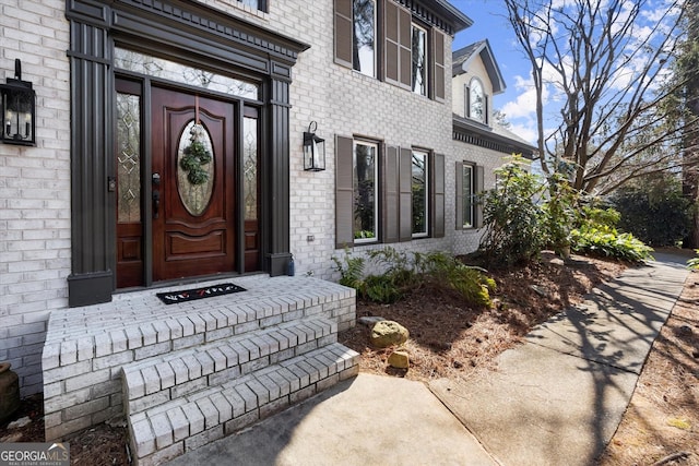 property entrance featuring brick siding