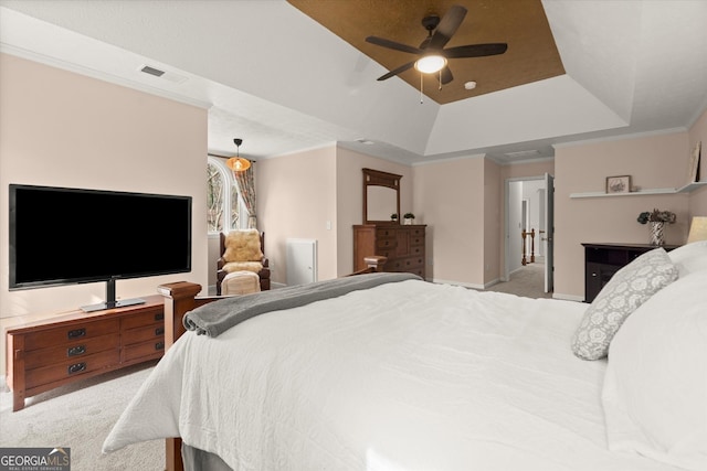 carpeted bedroom featuring ceiling fan, visible vents, ornamental molding, and a raised ceiling