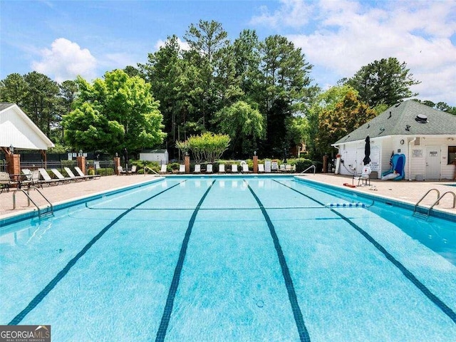 pool with fence and a patio