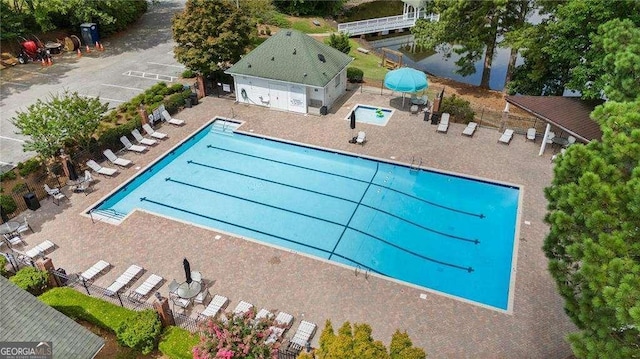 pool with a patio area and fence