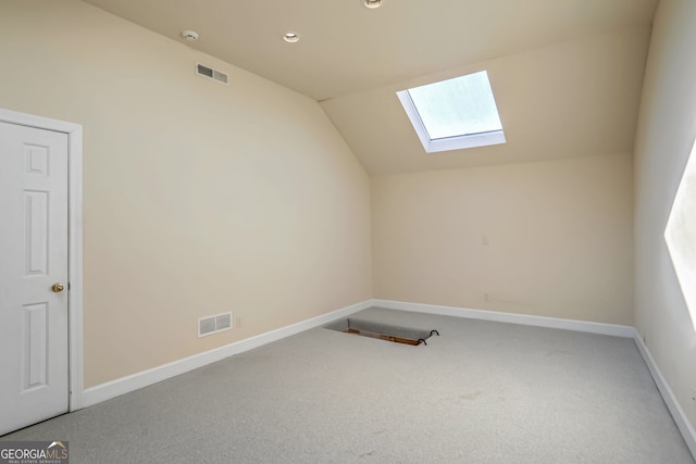 bonus room featuring vaulted ceiling with skylight, visible vents, and baseboards