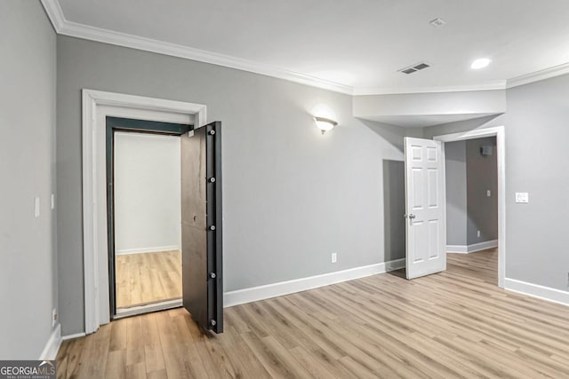 unfurnished room featuring baseboards, ornamental molding, visible vents, and light wood-style floors