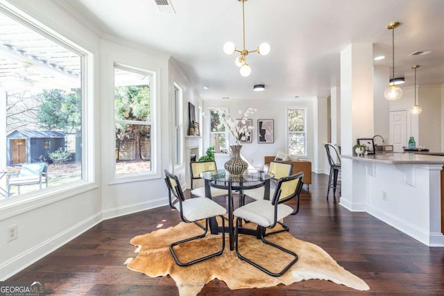 dining room with a healthy amount of sunlight, an inviting chandelier, baseboards, and dark wood finished floors