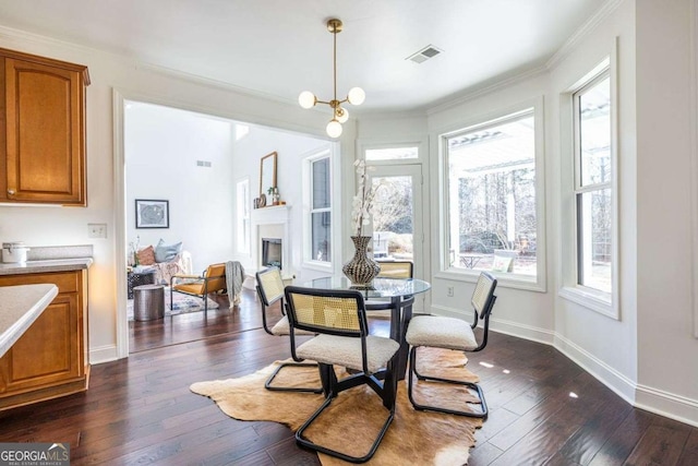 dining space with dark wood-style floors, a fireplace, crown molding, visible vents, and baseboards