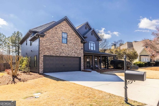 traditional-style house with driveway, stone siding, and a garage