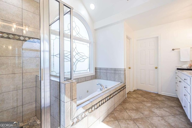 bathroom with vanity, vaulted ceiling, a jetted tub, tile patterned floors, and a stall shower