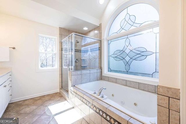 bathroom with a stall shower, baseboards, tile patterned floors, a jetted tub, and vanity