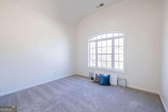 unfurnished room with lofted ceiling, visible vents, a wealth of natural light, and carpet flooring