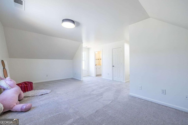 interior space with lofted ceiling, carpet floors, visible vents, and baseboards