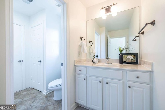 bathroom featuring visible vents, vanity, and toilet