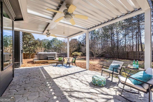 view of patio / terrace featuring a hot tub, ceiling fan, and a fenced backyard