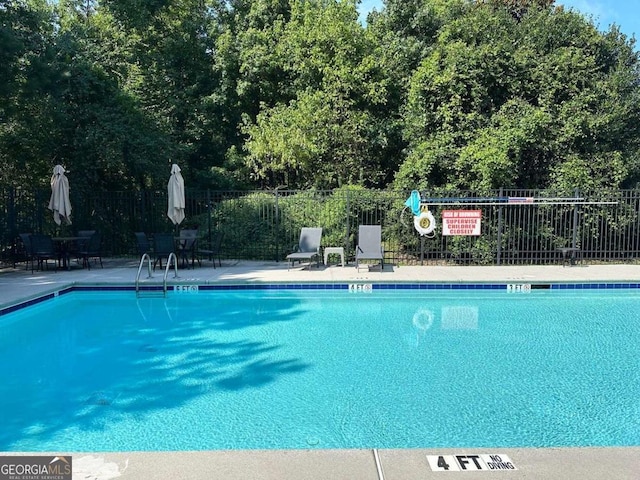 community pool featuring a patio area and fence