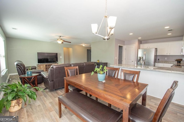 dining area featuring ceiling fan with notable chandelier, light wood finished floors, visible vents, and recessed lighting