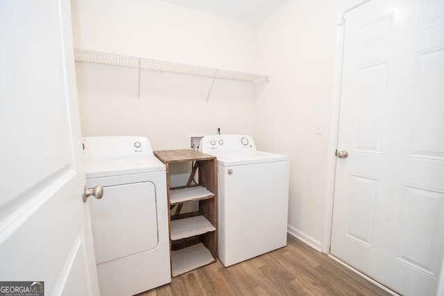 laundry room with laundry area, washing machine and dryer, and light wood-style floors