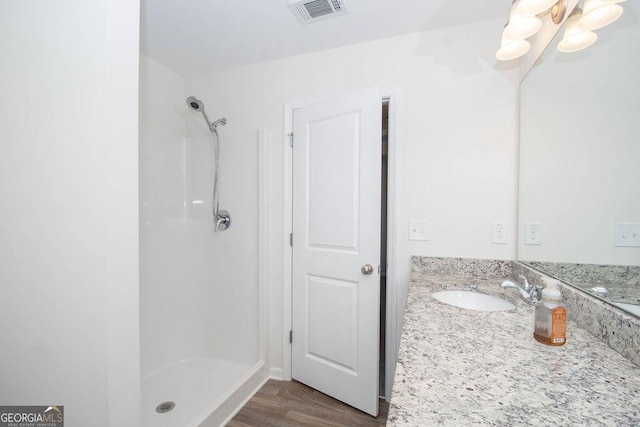 full bath featuring visible vents, a shower stall, vanity, and wood finished floors