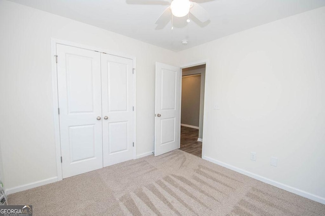 unfurnished bedroom with carpet floors, a closet, and baseboards