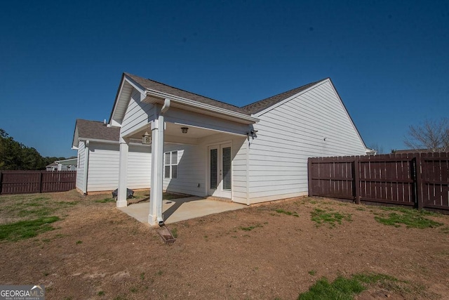 back of property with a fenced backyard and a patio