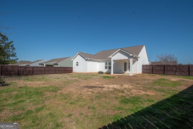 rear view of property with a lawn and a fenced backyard