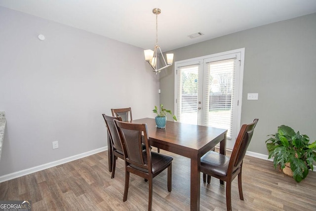 dining room with wood finished floors, visible vents, and baseboards