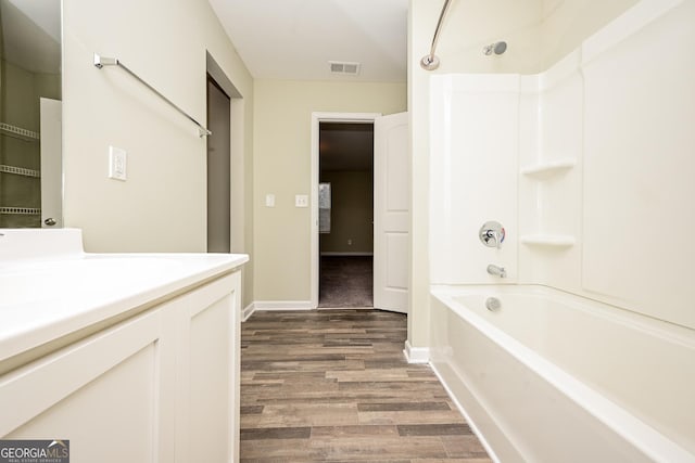 bathroom with visible vents, shower / bathing tub combination, vanity, wood finished floors, and baseboards