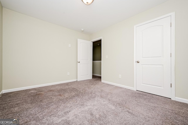 unfurnished bedroom featuring carpet and baseboards