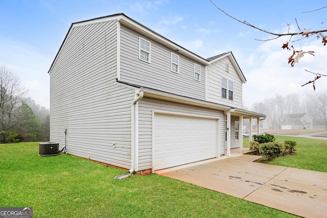 view of side of home featuring a garage, a yard, central AC, and driveway