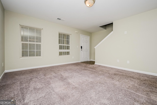 carpeted empty room featuring visible vents and baseboards