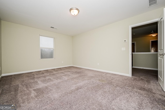 carpeted empty room featuring visible vents and baseboards