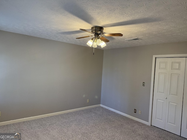 spare room with carpet, visible vents, ceiling fan, a textured ceiling, and baseboards