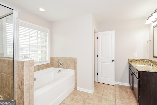 full bathroom featuring baseboards, vanity, a bath, and tile patterned floors