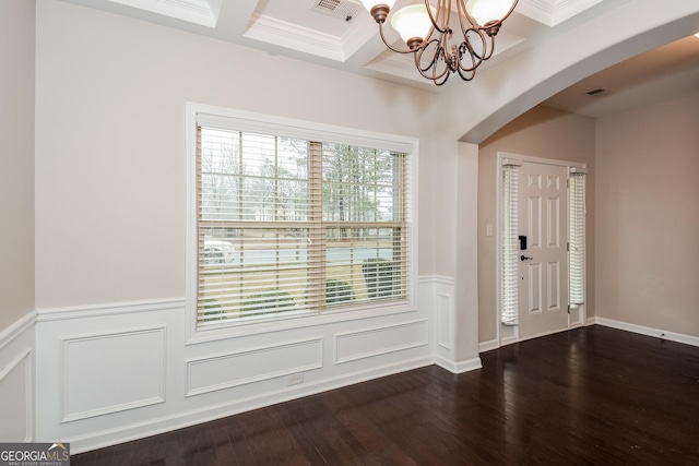 foyer entrance featuring dark wood-style floors, arched walkways, coffered ceiling, and visible vents