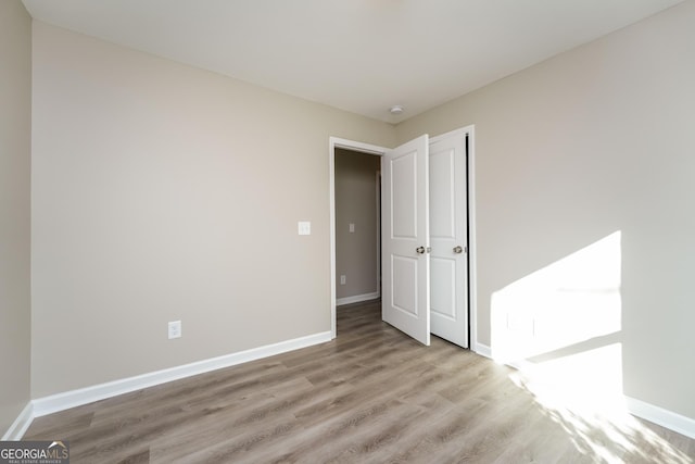 unfurnished bedroom with light wood-style flooring and baseboards