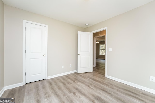 unfurnished bedroom featuring light wood-style flooring and baseboards