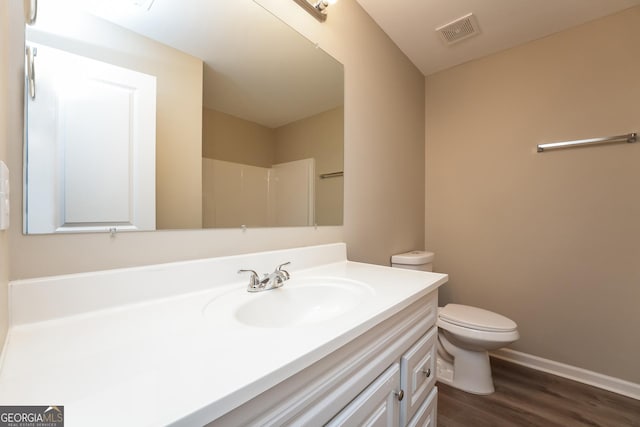 full bathroom with visible vents, toilet, vanity, wood finished floors, and walk in shower