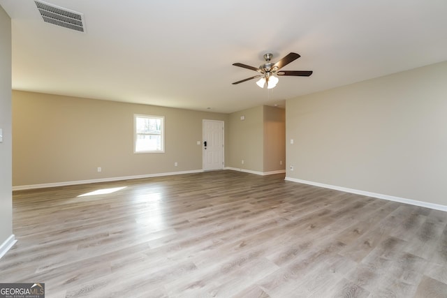 unfurnished room with light wood-style floors, baseboards, visible vents, and a ceiling fan