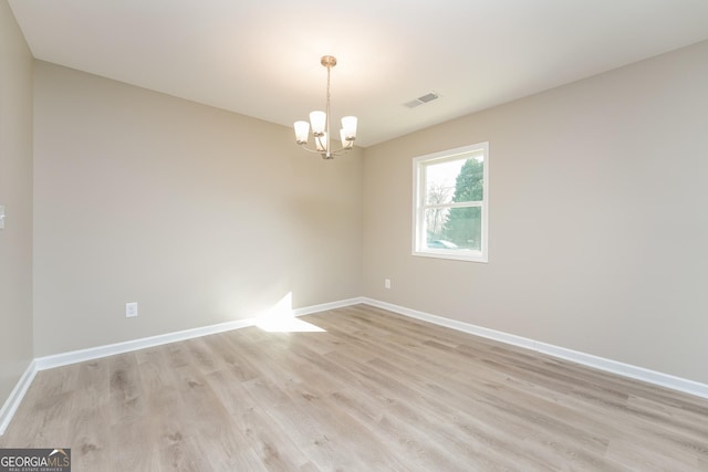 empty room featuring light wood-type flooring, visible vents, and baseboards